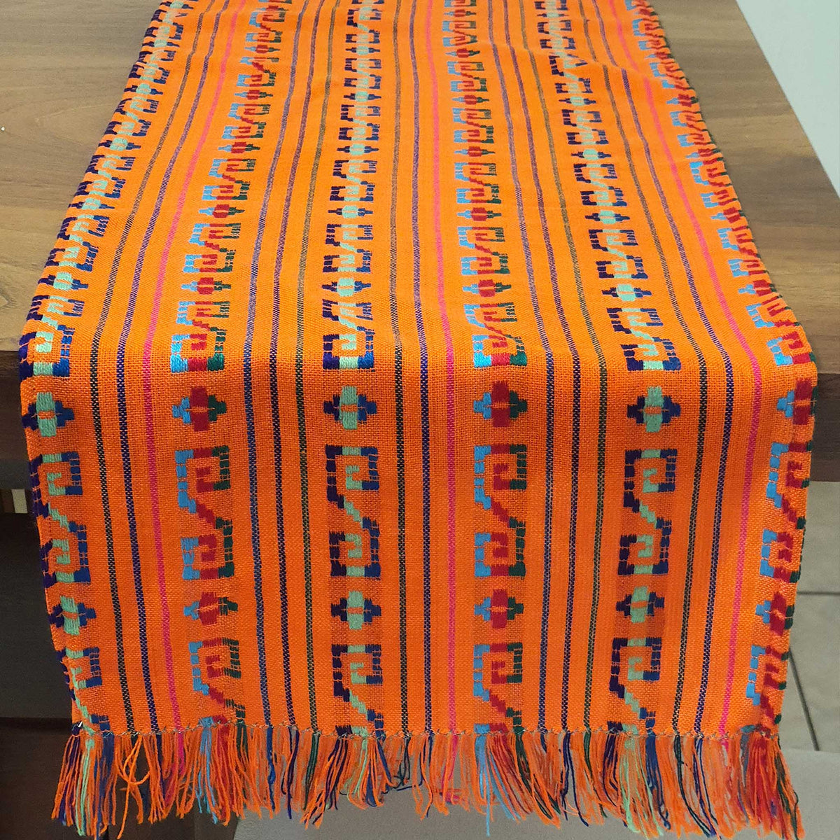 Colorful woven textile with patterns on a wooden surface