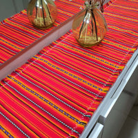 Colorful striped table runner on a white table with 'innate' branding.