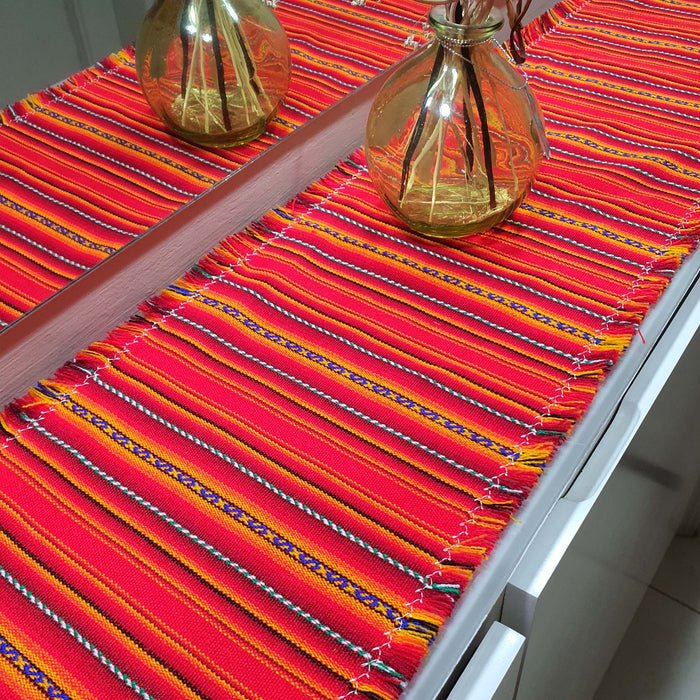Colorful striped table runner on a white table with 'innate' branding.