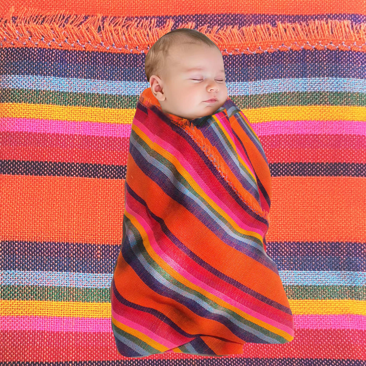 Baby swaddled in a colorful striped blanket on a multicolored fabric background