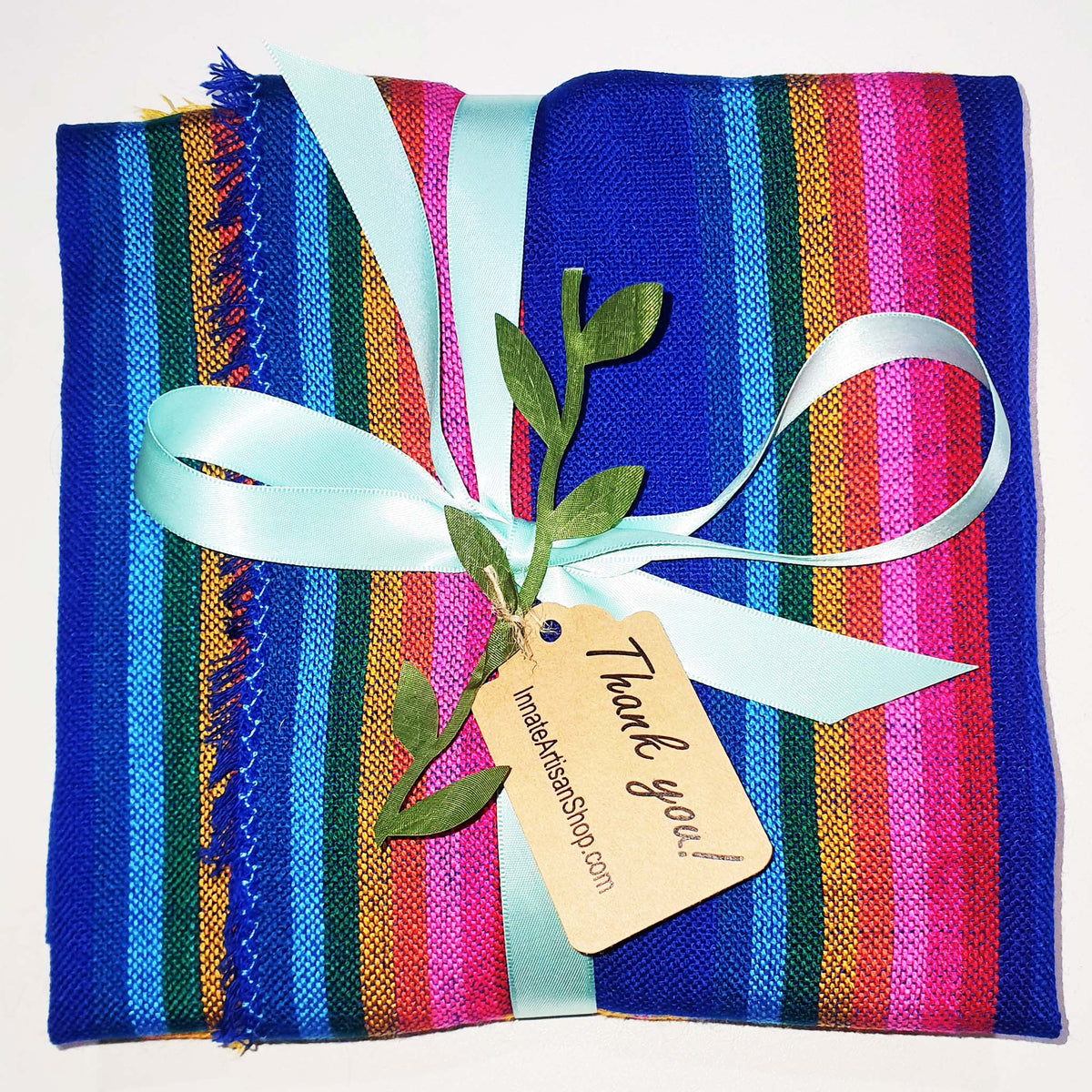 Colorful striped fabric with a blue ribbon and 'Thank you' tag on a white background