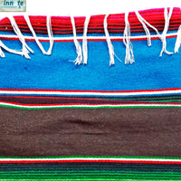 Colorful woven fabric with red, blue, green, and white stripes on a white background.